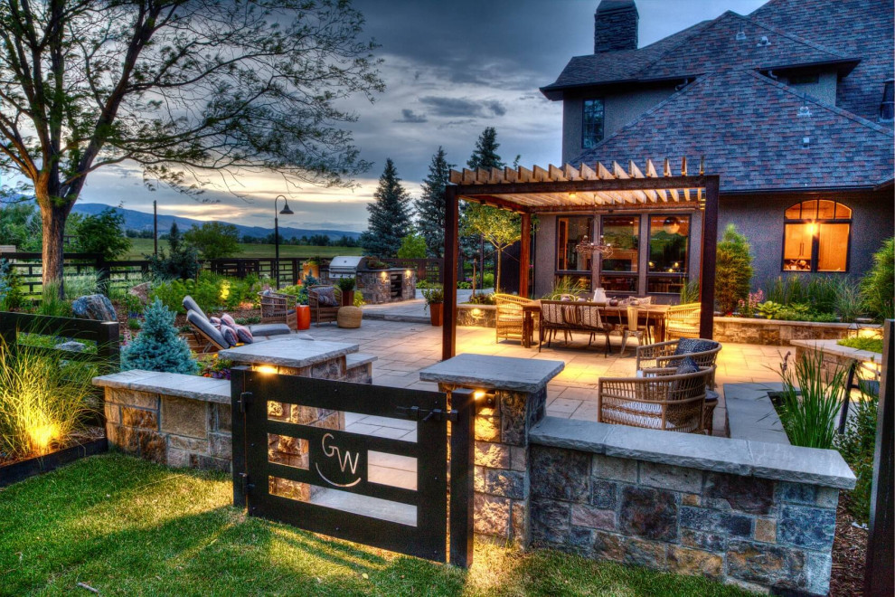 Large country backyard garden in Denver with with a gate and natural stone pavers.
