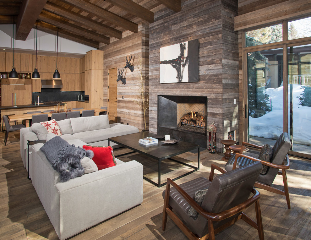 Country open concept living room in Denver with brown walls, light hardwood floors, a standard fireplace and a wood fireplace surround.