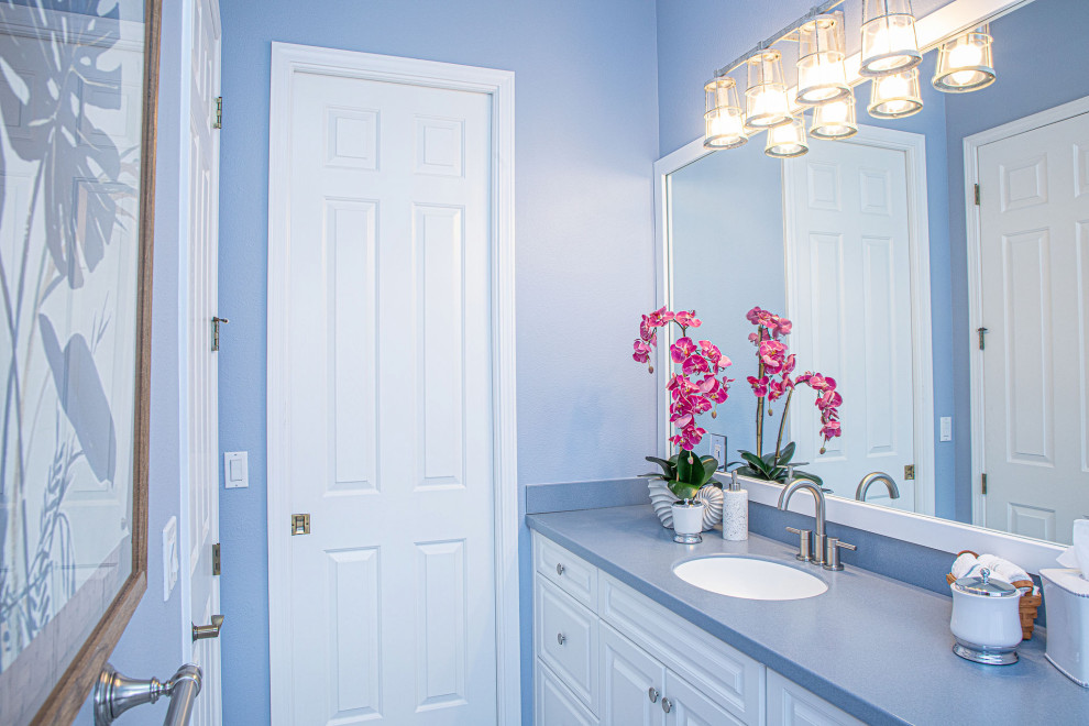 Esempio di una stanza da bagno padronale minimal di medie dimensioni con ante in stile shaker, ante bianche, vasca ad angolo, vasca/doccia, WC monopezzo, pareti blu, lavabo sospeso, top blu, un lavabo e mobile bagno incassato