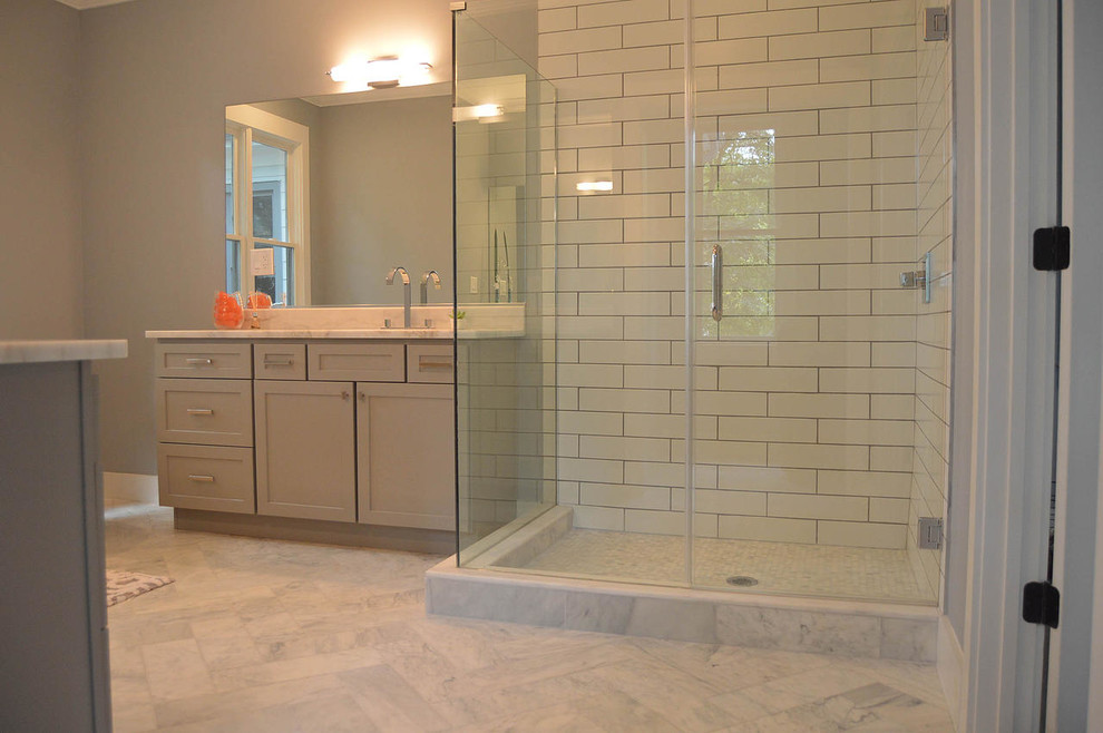Inspiration for a large transitional master bathroom in Atlanta with an undermount sink, shaker cabinets, grey cabinets, granite benchtops, a freestanding tub, a corner shower, a one-piece toilet, white tile, subway tile, grey walls, marble floors, white floor, a hinged shower door and white benchtops.