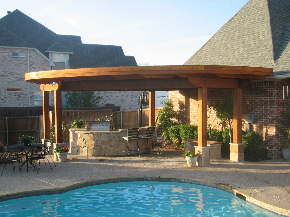 Design ideas for a large traditional backyard patio in Dallas with a water feature, natural stone pavers and an awning.