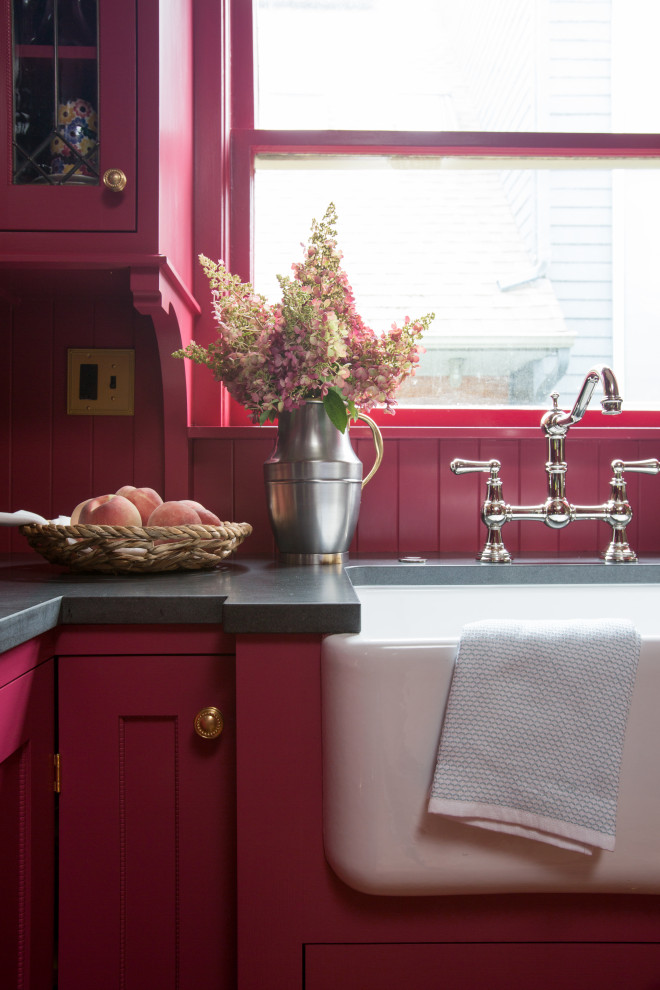 Photo of a small traditional l-shaped separate kitchen in Seattle with a farmhouse sink, shaker cabinets, pink cabinets, granite benchtops, pink splashback, timber splashback, panelled appliances, light hardwood floors, no island, brown floor and black benchtop.