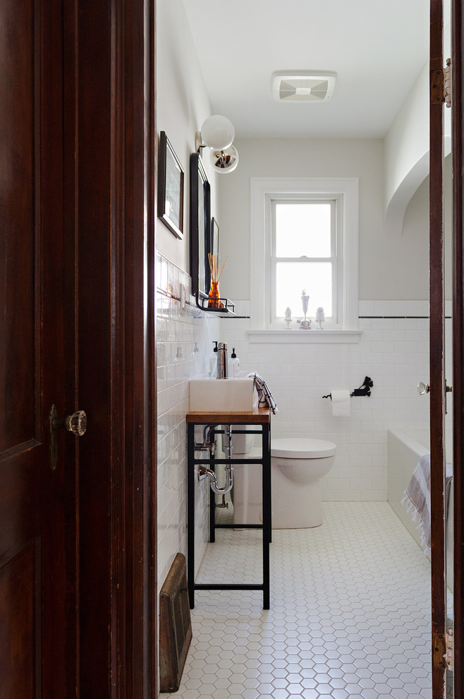 Small transitional master white tile and ceramic tile ceramic tile and white floor alcove bathtub photo with open cabinets, medium tone wood cabinets, a one-piece toilet, gray walls, a vessel sink and wood countertops