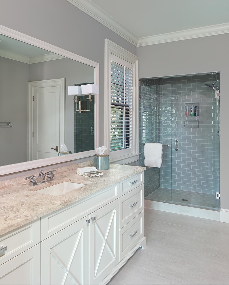 This is an example of a mid-sized bathroom in Charleston with furniture-like cabinets, white cabinets, gray tile, glass tile, grey walls, cement tiles, an undermount sink, granite benchtops, grey floor and a hinged shower door.