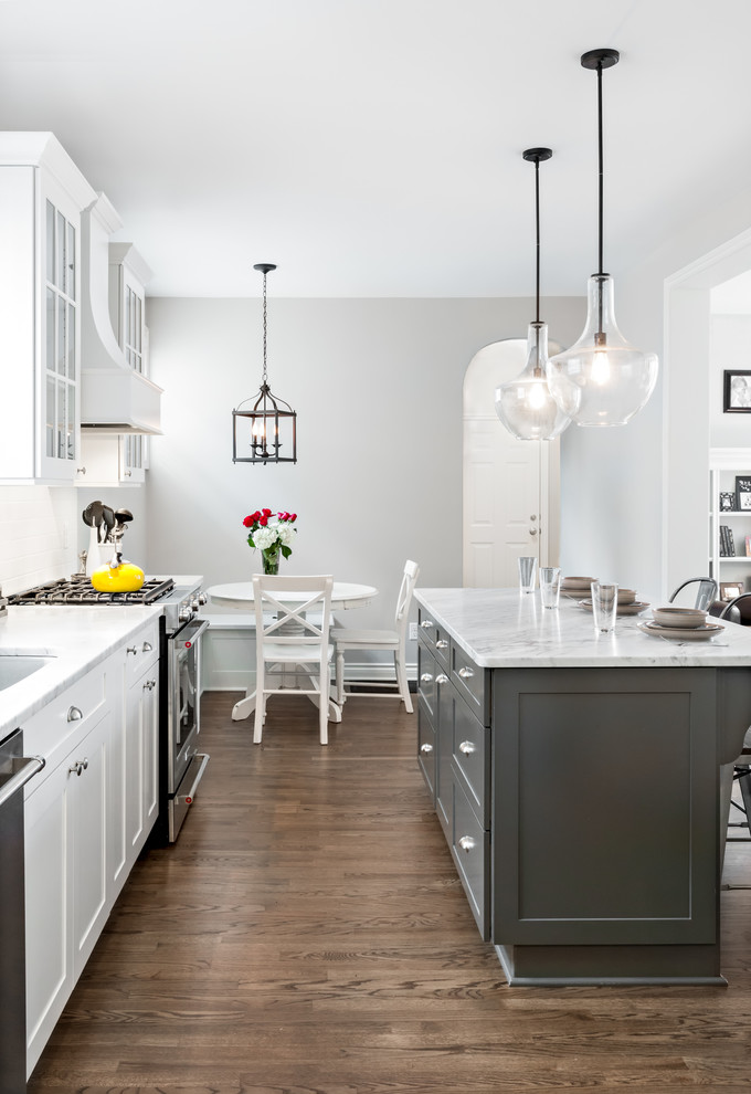 Eat-in kitchen - large transitional l-shaped medium tone wood floor eat-in kitchen idea in Detroit with shaker cabinets, white cabinets, marble countertops, white backsplash, subway tile backsplash, stainless steel appliances and an island