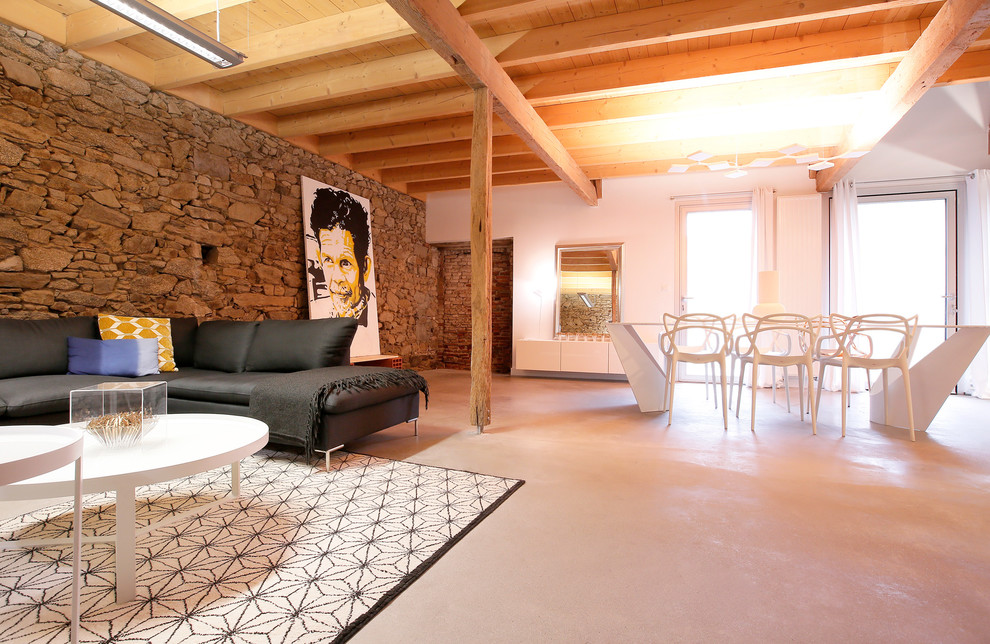 This is an example of a large contemporary open concept family room in Angers with concrete floors.