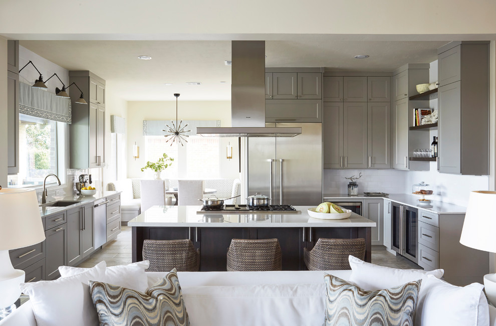 Inspiration for a transitional u-shaped beige floor open concept kitchen remodel in Houston with an undermount sink, shaker cabinets, gray cabinets, white backsplash, subway tile backsplash, stainless steel appliances and an island