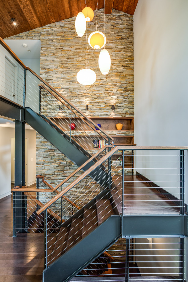 Inspiration for a mid-sized industrial wood u-shaped staircase in Cleveland with cable railing and open risers.