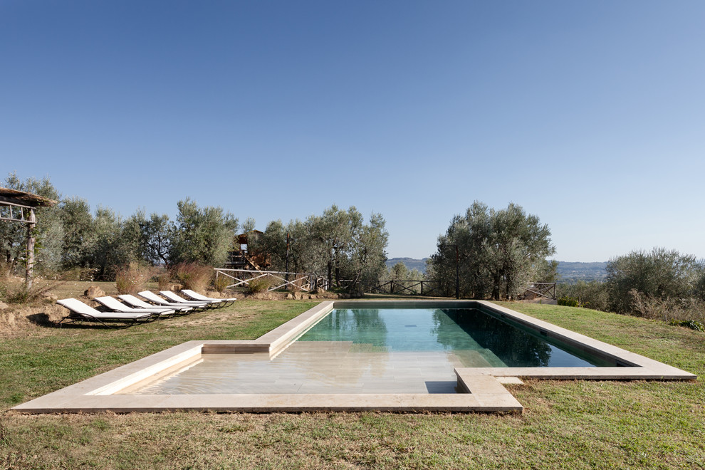 This is an example of a country backyard custom-shaped lap pool in Florence.