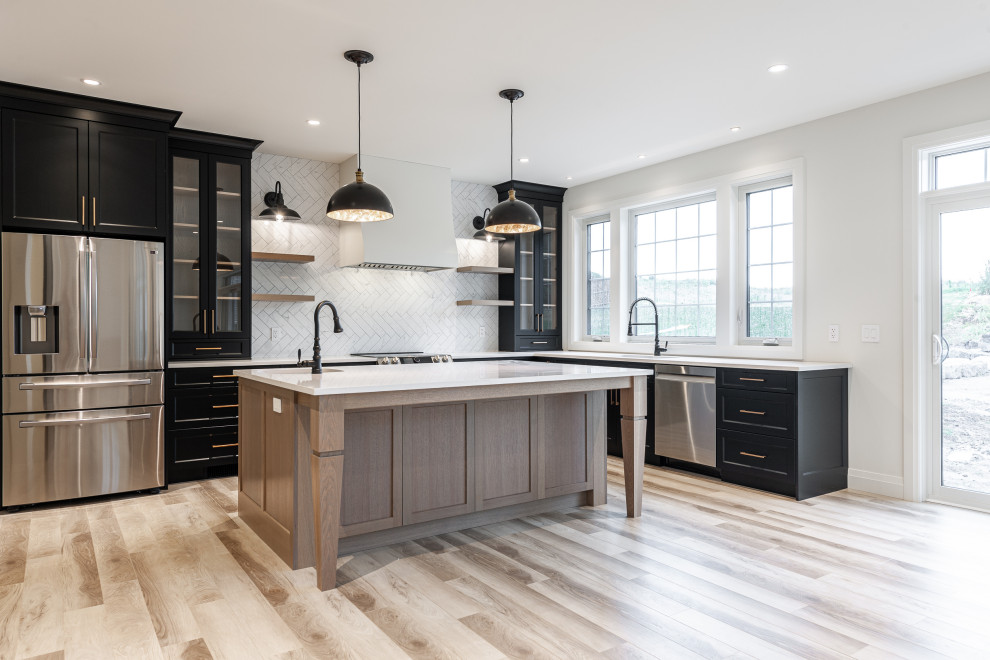 Eat-in kitchen - mid-sized transitional l-shaped laminate floor and brown floor eat-in kitchen idea in Toronto with an undermount sink, recessed-panel cabinets, black cabinets, quartz countertops, white backsplash, ceramic backsplash, stainless steel appliances, an island and white countertops