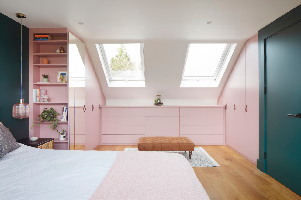 Imagen de dormitorio principal actual grande con paredes verdes y suelo de madera en tonos medios