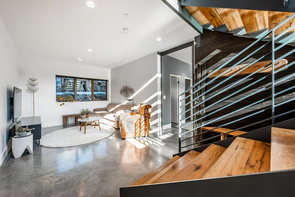 Mittelgroße Moderne Holztreppe in L-Form mit offenen Setzstufen, Stahlgeländer und Holzwänden in Sonstige