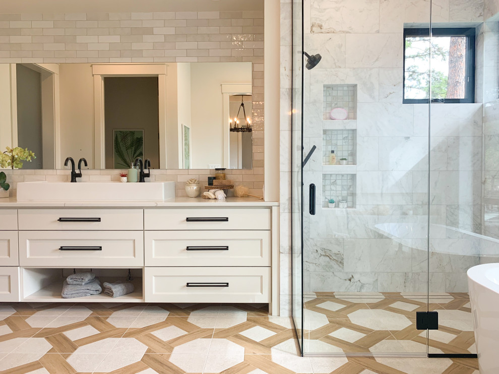 Photo of a transitional master bathroom in Seattle with recessed-panel cabinets, white cabinets, a freestanding tub, a corner shower, white tile, a vessel sink, multi-coloured floor, a hinged shower door and white benchtops.
