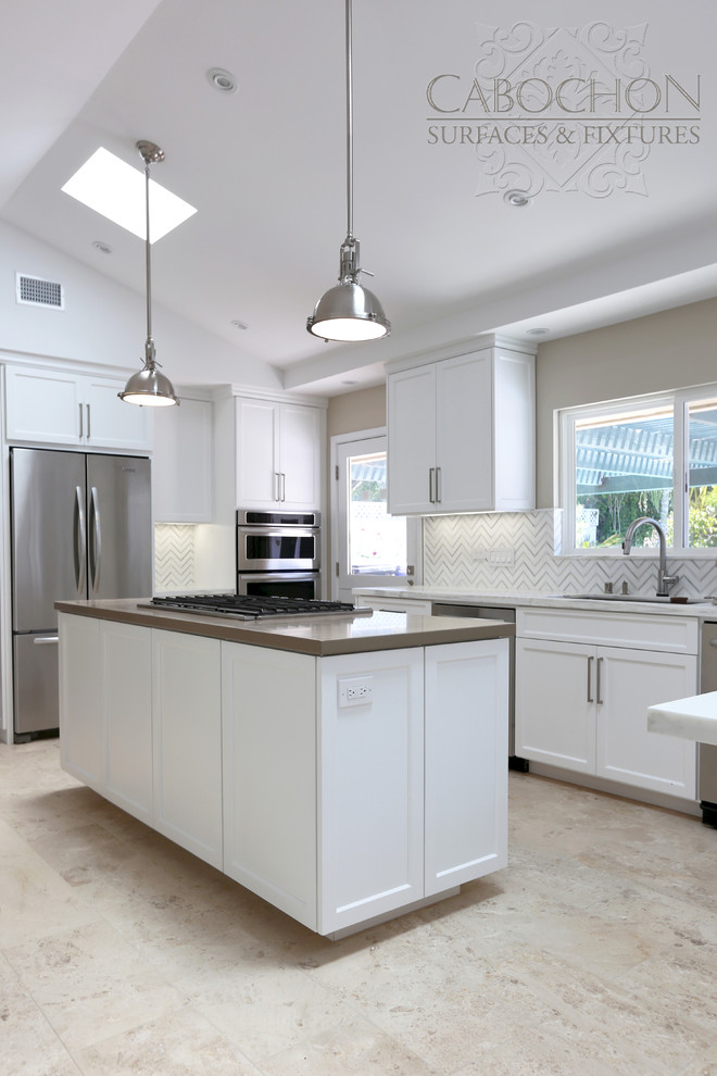 Example of a mid-sized transitional l-shaped limestone floor open concept kitchen design in San Diego with an island, shaker cabinets, white cabinets, marble countertops, white backsplash, mosaic tile backsplash, stainless steel appliances, an undermount sink and beige walls