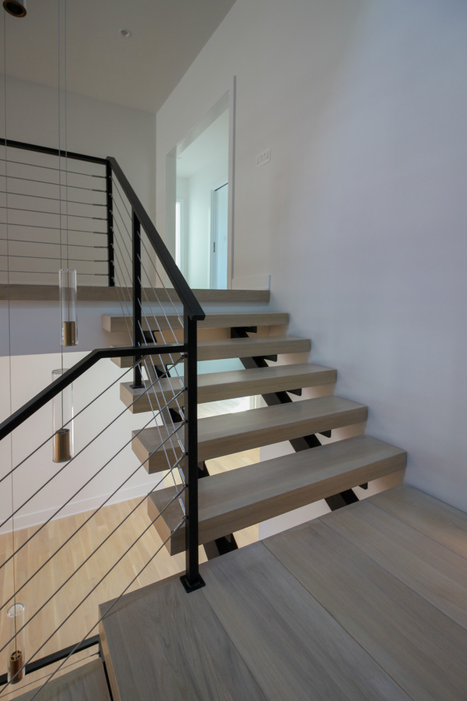 Diseño de escalera suspendida bohemia grande con escalones de madera, barandilla de metal y ladrillo