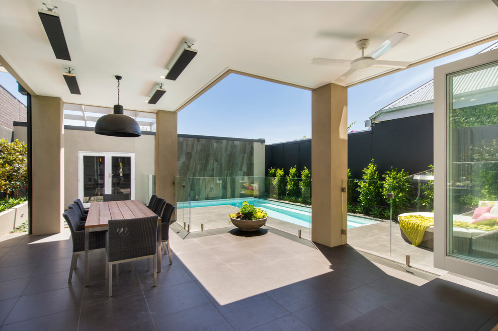 Photo of a mid-sized traditional backyard patio in Melbourne with tile and a roof extension.