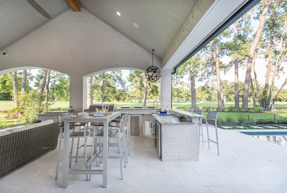Photo of a large beach style backyard patio in Houston with an outdoor kitchen, tile and a roof extension.