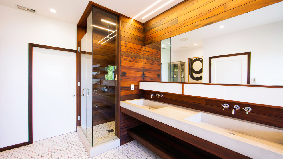 Modern master bathroom in San Francisco with medium wood cabinets, a wall-mount toilet, ceramic floors, a wall-mount sink, concrete benchtops, white floor, grey benchtops, a double vanity, a floating vanity and wood walls.
