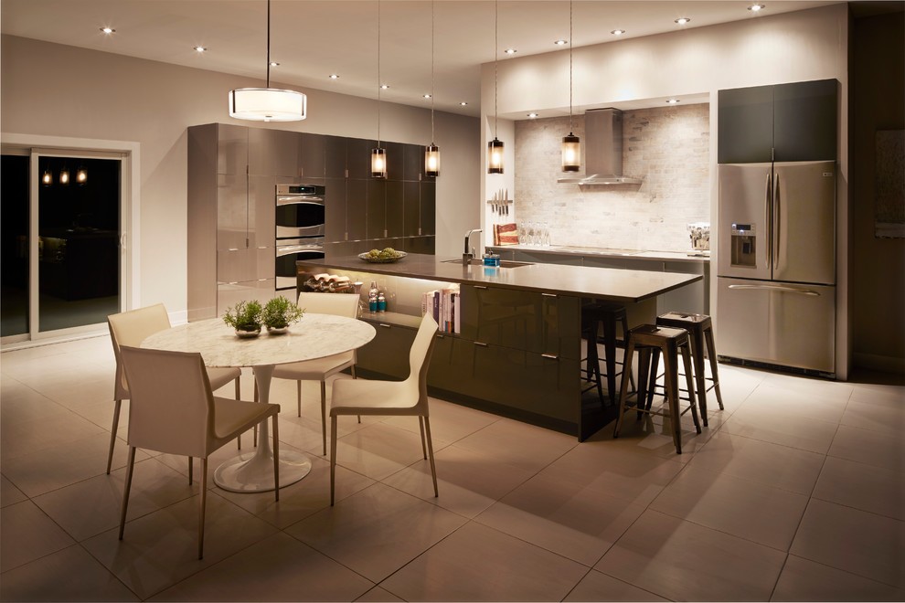 Inspiration for a large modern galley open plan kitchen in Atlanta with an undermount sink, flat-panel cabinets, grey cabinets, quartz benchtops, beige splashback, stone tile splashback, stainless steel appliances, porcelain floors, with island and grey floor.