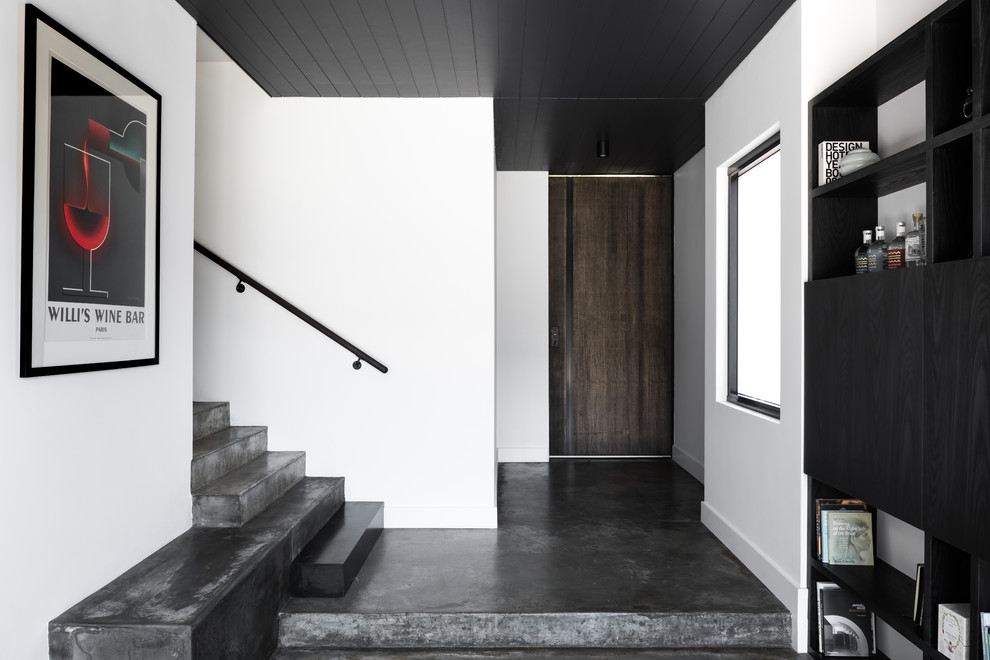 Photo of a contemporary entry hall in Perth with white walls, concrete floors, a single front door, a dark wood front door and grey floor.