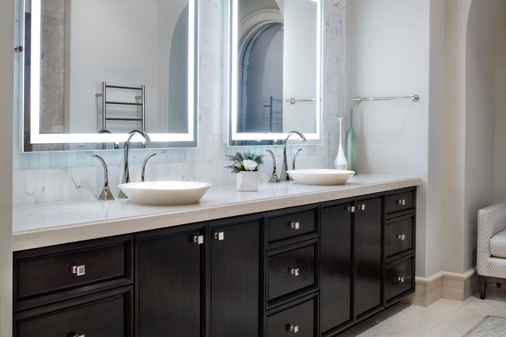 This is an example of an expansive transitional master bathroom in Austin with recessed-panel cabinets, dark wood cabinets, marble and a vessel sink.