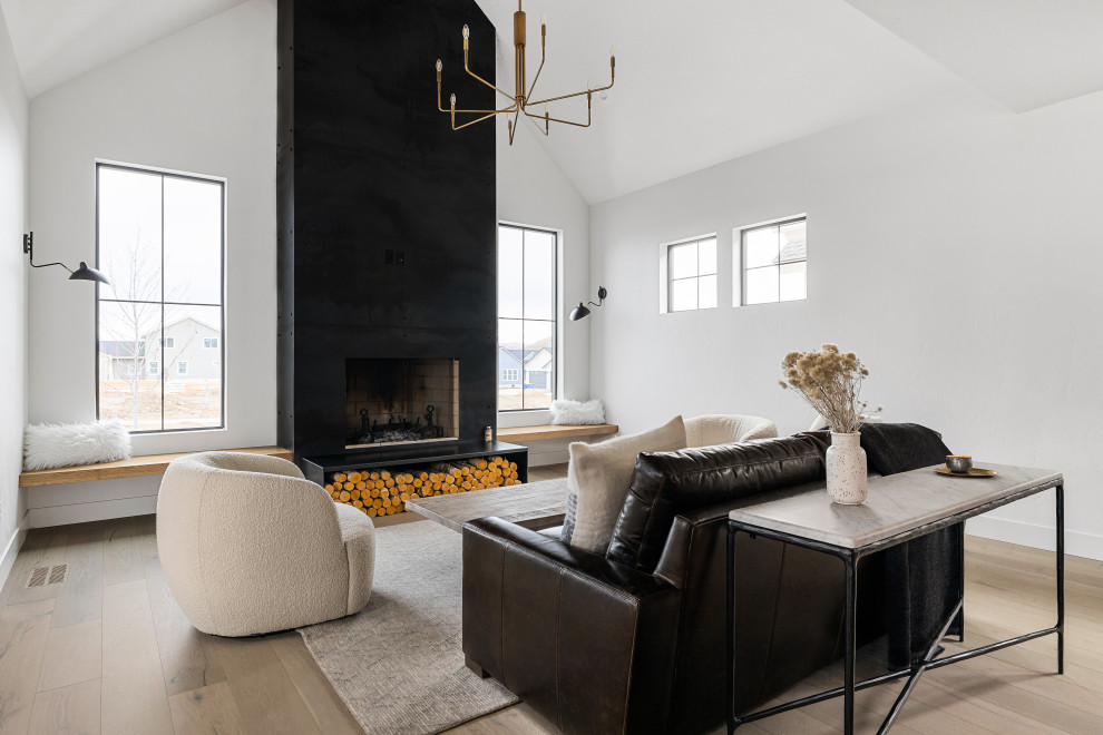 Inspiration for a mid-sized scandinavian open concept living room in Boise with white walls, light hardwood floors, a wood stove, a metal fireplace surround, no tv, beige floor and vaulted.