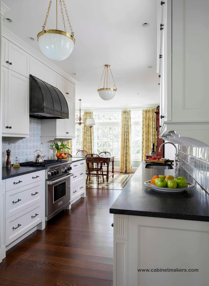 This is an example of a traditional open plan kitchen in Boston with white cabinets and grey splashback.