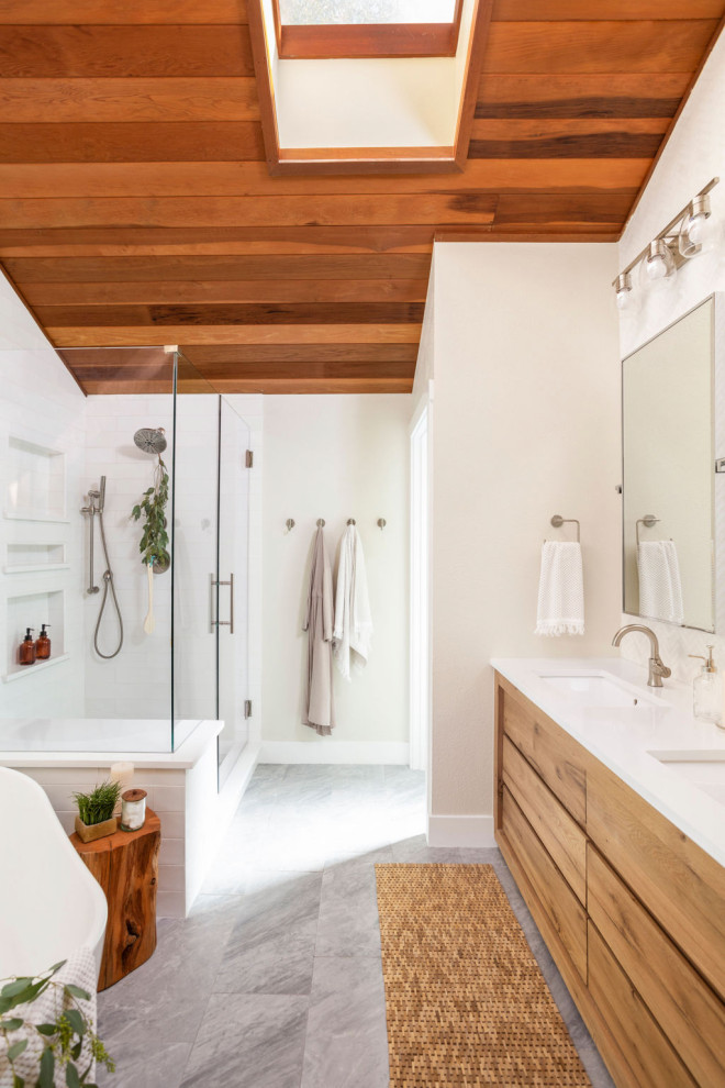 Photo of a mid-sized midcentury master bathroom in Denver with flat-panel cabinets, light wood cabinets, a freestanding tub, a corner shower, white tile, ceramic tile, white walls, porcelain floors, an undermount sink, engineered quartz benchtops, grey floor, a hinged shower door, white benchtops, a shower seat, a double vanity, a built-in vanity and wood.