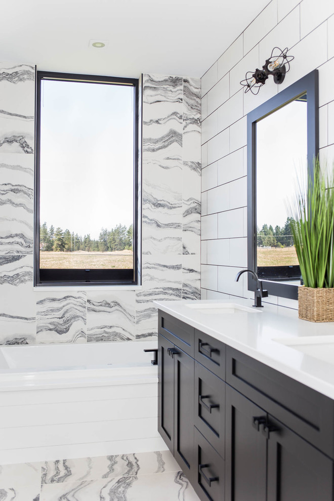 Inspiration for a large modern master bathroom in Seattle with recessed-panel cabinets, black cabinets, a corner tub, an open shower, a one-piece toilet, white tile, marble, white walls, marble floors, an integrated sink, solid surface benchtops, white floor, an open shower and white benchtops.