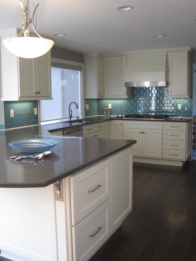 Example of a mid-sized transitional u-shaped dark wood floor open concept kitchen design in Seattle with an undermount sink, shaker cabinets, white cabinets, quartz countertops, blue backsplash, glass tile backsplash, stainless steel appliances and a peninsula