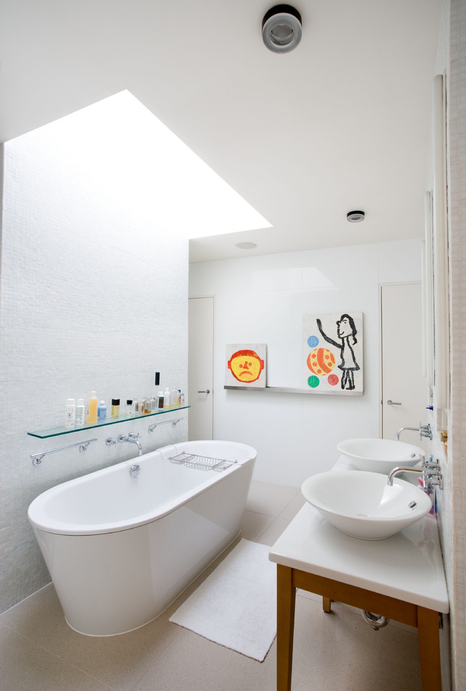 Photo of a contemporary kids bathroom in New York with a freestanding tub and a vessel sink.