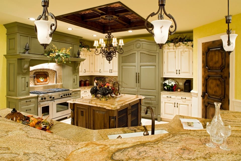 Large traditional l-shaped eat-in kitchen in Chicago with a double-bowl sink, green cabinets, beige splashback, multiple islands, raised-panel cabinets, panelled appliances, granite benchtops and ceramic floors.