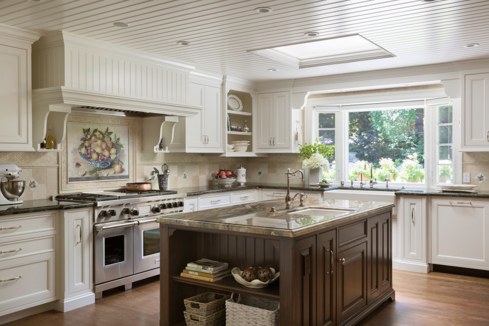 Inspiration for a traditional l-shaped kitchen in San Francisco with a farmhouse sink, recessed-panel cabinets, white cabinets, beige splashback, stainless steel appliances, medium hardwood floors, with island, brown floor and brown benchtop.