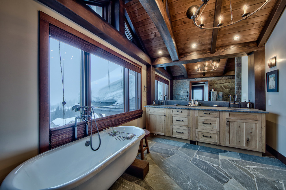 Inspiration for a large country master bathroom in Vancouver with flat-panel cabinets, light wood cabinets, a freestanding tub, an open shower, a one-piece toilet, beige walls, concrete floors, a drop-in sink and concrete benchtops.