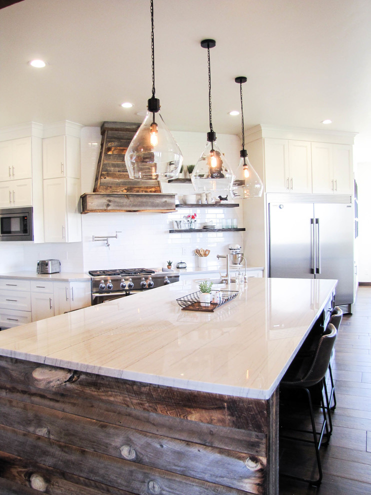 Example of a large transitional porcelain tile and brown floor kitchen design in Phoenix with white backsplash, subway tile backsplash, stainless steel appliances and an island