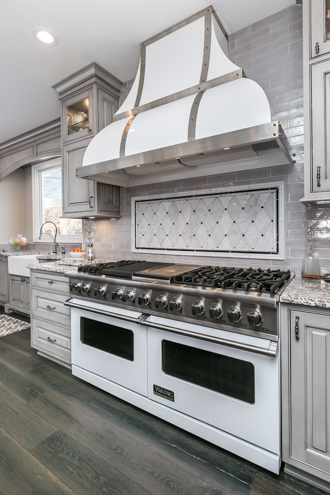 Inspiration for a large traditional u-shaped eat-in kitchen in Baltimore with a farmhouse sink, beaded inset cabinets, grey cabinets, granite benchtops, grey splashback, white appliances, medium hardwood floors, with island and grey floor.