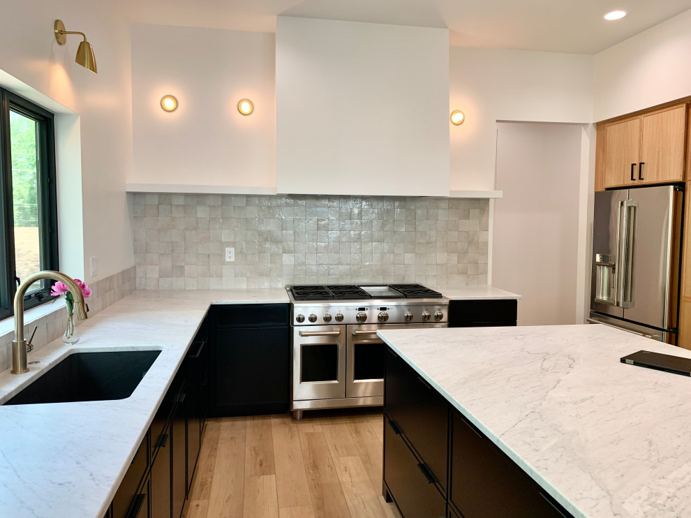 Large scandi u-shaped kitchen/diner in Other with a submerged sink, shaker cabinets, black cabinets, marble worktops, multi-coloured splashback, stainless steel appliances, vinyl flooring, an island, brown floors and white worktops.