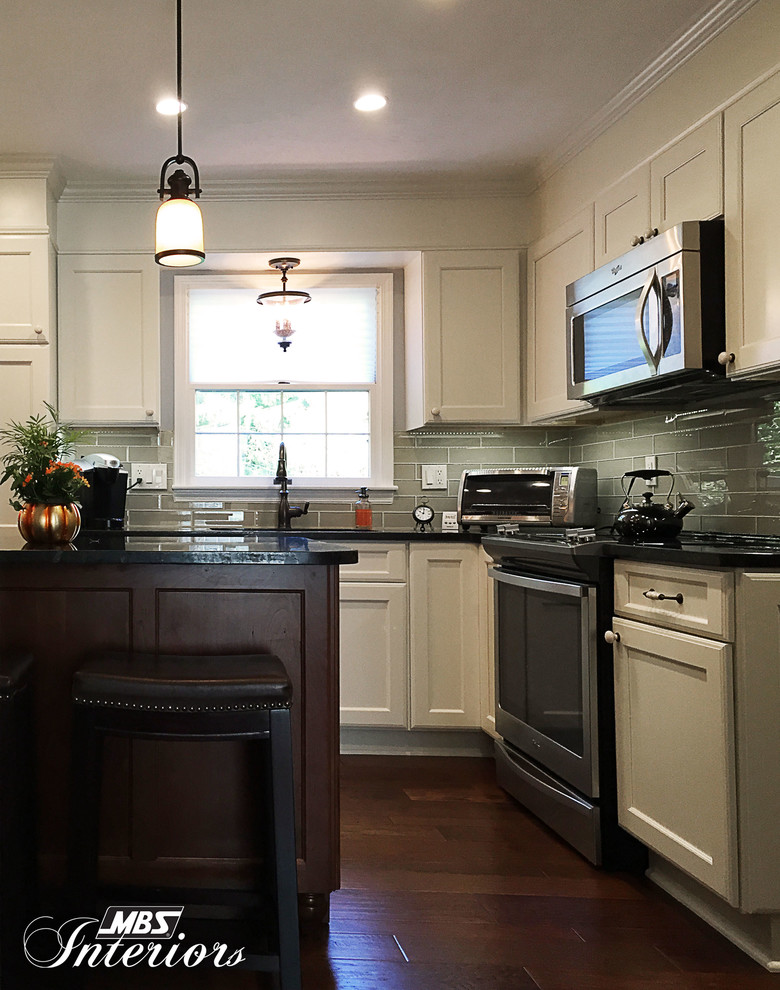 Mid-sized transitional l-shaped medium tone wood floor and brown floor eat-in kitchen photo with an undermount sink, white cabinets, granite countertops, gray backsplash, subway tile backsplash, stainless steel appliances, an island and recessed-panel cabinets