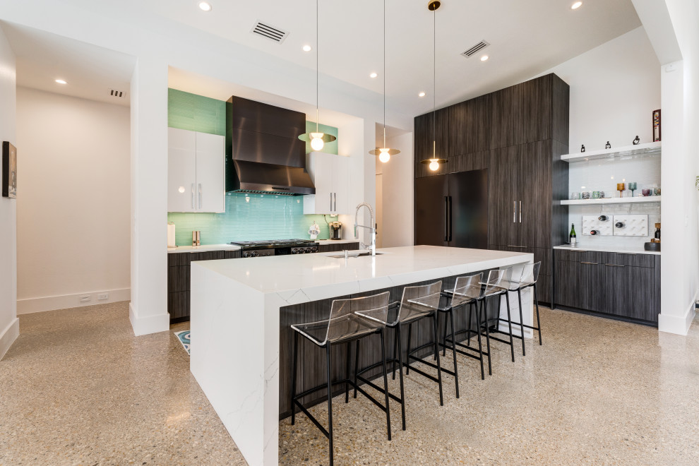 This is an example of a contemporary l-shaped open plan kitchen in Dallas with an undermount sink, flat-panel cabinets, quartz benchtops, green splashback, glass tile splashback, black appliances, concrete floors, with island, grey floor, white benchtop, grey cabinets and vaulted.