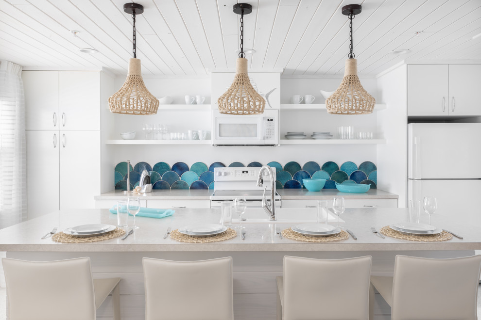 Photo of a small beach style galley eat-in kitchen in Tampa with a drop-in sink, flat-panel cabinets, white cabinets, laminate benchtops, blue splashback, mosaic tile splashback, stainless steel appliances, ceramic floors, with island, white floor, white benchtop and wood.
