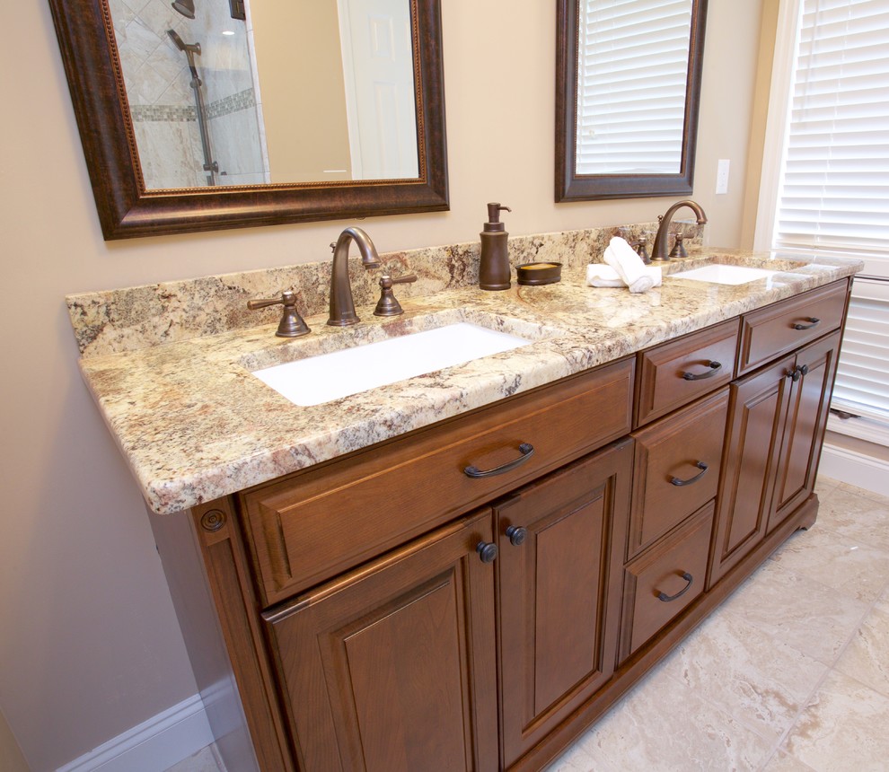 This is an example of a mid-sized traditional bathroom in Other with raised-panel cabinets and medium wood cabinets.