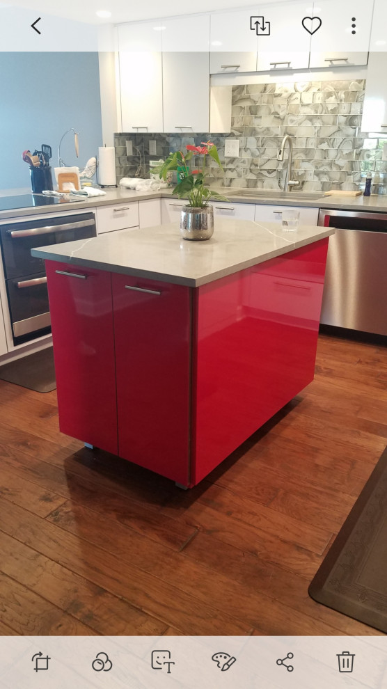 This is an example of a mid-sized modern u-shaped kitchen in Jacksonville with flat-panel cabinets, red cabinets, quartz benchtops, beige splashback, marble splashback, stainless steel appliances, with island and beige benchtop.