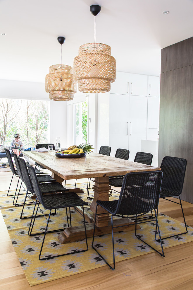 Inspiration for a large beach style open plan dining in Melbourne with white walls, light hardwood floors and brown floor.