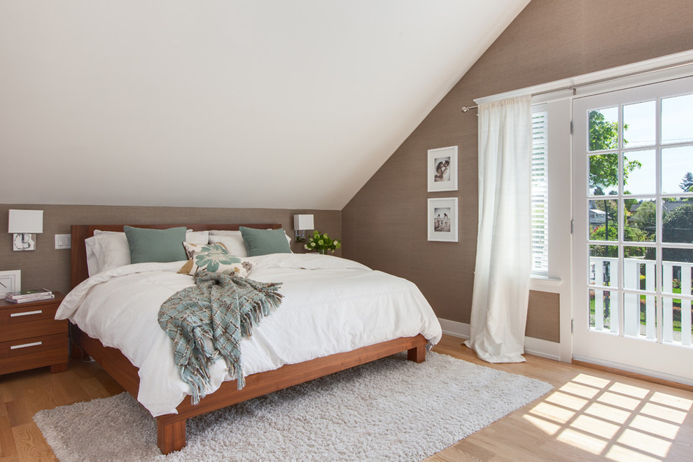 This is an example of a large transitional master bedroom in Vancouver with brown walls, light hardwood floors and no fireplace.