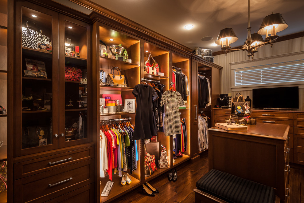 This is an example of a large transitional women's dressing room in Seattle with recessed-panel cabinets, medium wood cabinets and dark hardwood floors.