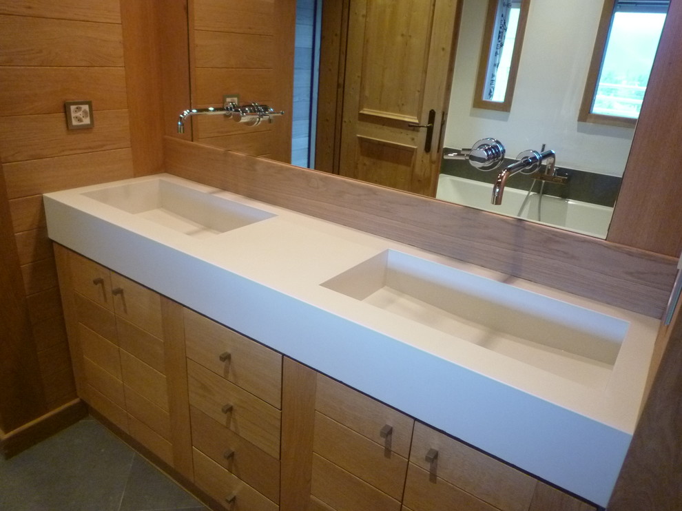 Expansive contemporary master bathroom in Angers with concrete benchtops and an integrated sink.
