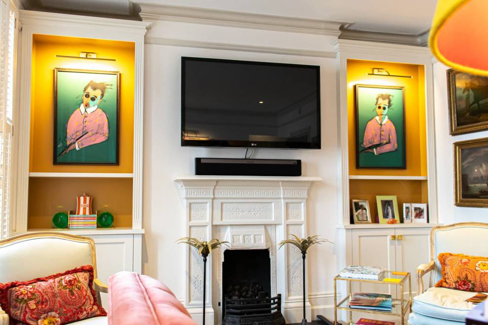 Стильный дизайн: гостиная комната среднего размера в классическом стиле с оранжевыми стенами, ковровым покрытием, стандартным камином, фасадом камина из камня, телевизором на стене и бежевым полом - последний тренд
