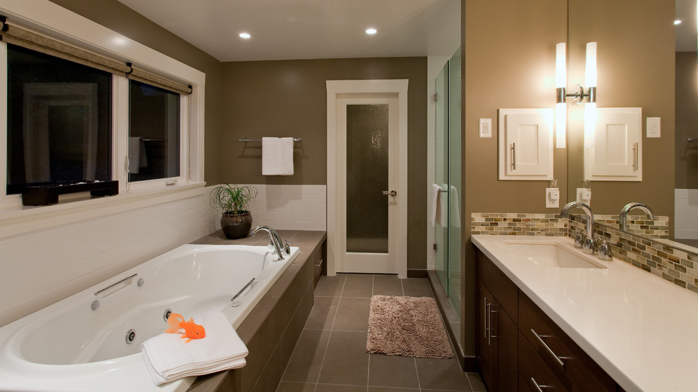 Inspiration for a large contemporary kids bathroom in Vancouver with an undermount sink, flat-panel cabinets, dark wood cabinets, a drop-in tub, an alcove shower, brown tile, brown floor, mosaic tile, beige walls, ceramic floors, engineered quartz benchtops, a hinged shower door and white benchtops.