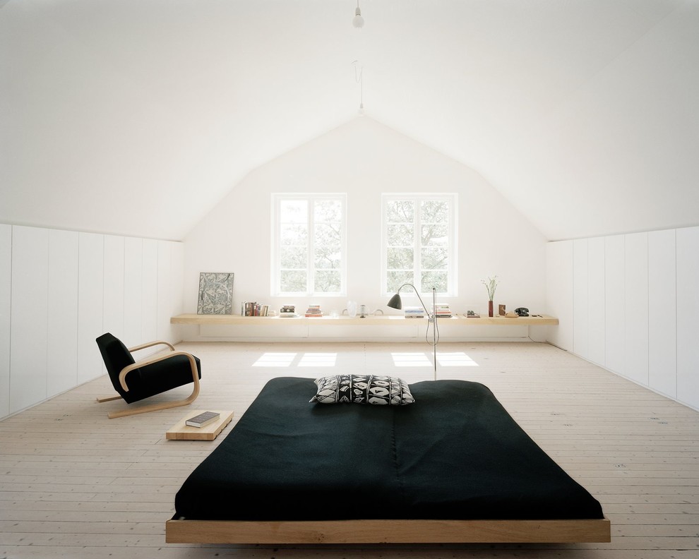 Expansive scandinavian master bedroom in London with white walls, light hardwood floors and no fireplace.