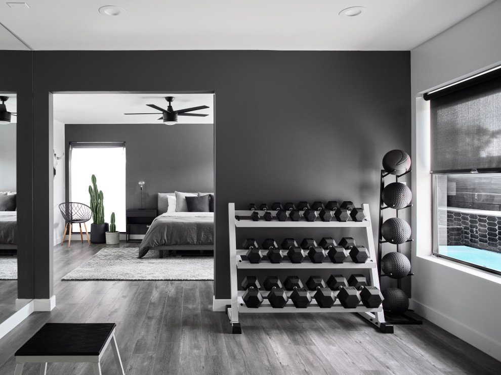 Photo of a contemporary home gym in Phoenix with black walls, dark hardwood floors and black floor.